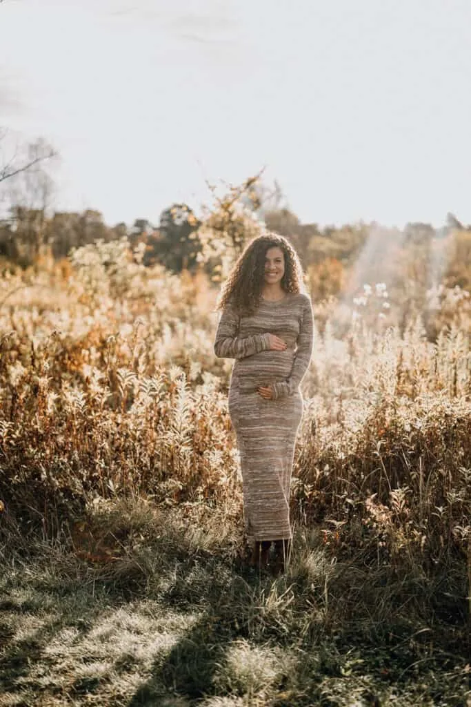 Schwangere Frau im Blumenfeld, Babybauch Fotoshooting Wien.