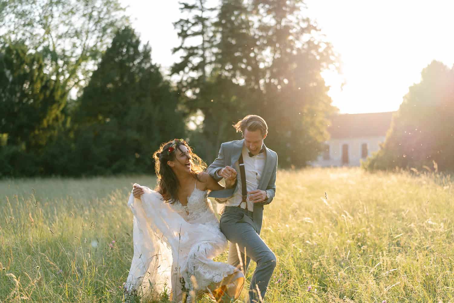 Braut und Bräutigam gehen durch sonnenbeschienene Wiese, Blumenkrone.