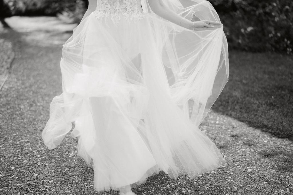 Braut geht im Freien, wallendes Brautkleid und Schleier.