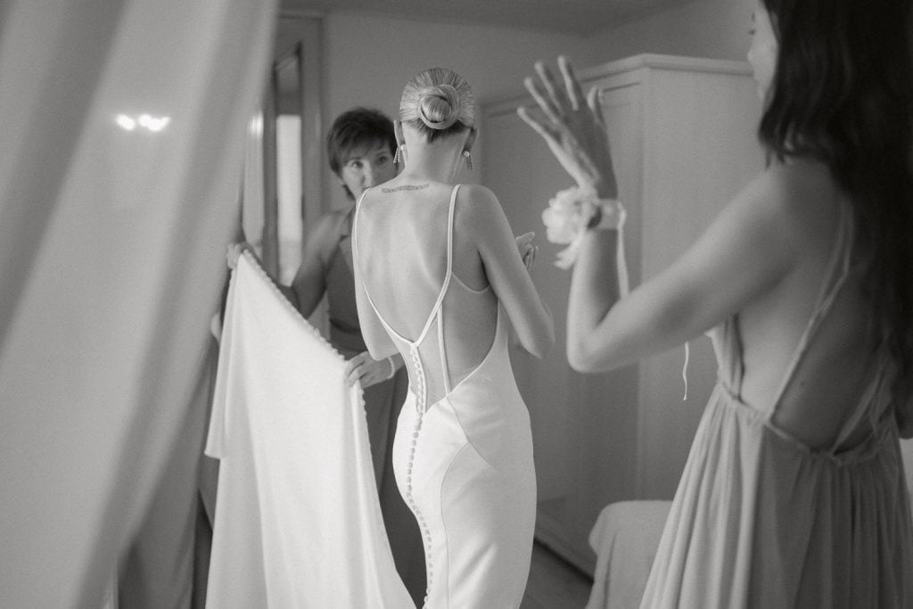 Braut im rückenfreien Hochzeitskleid, Getting Ready, Hochzeit im Himmelblau.