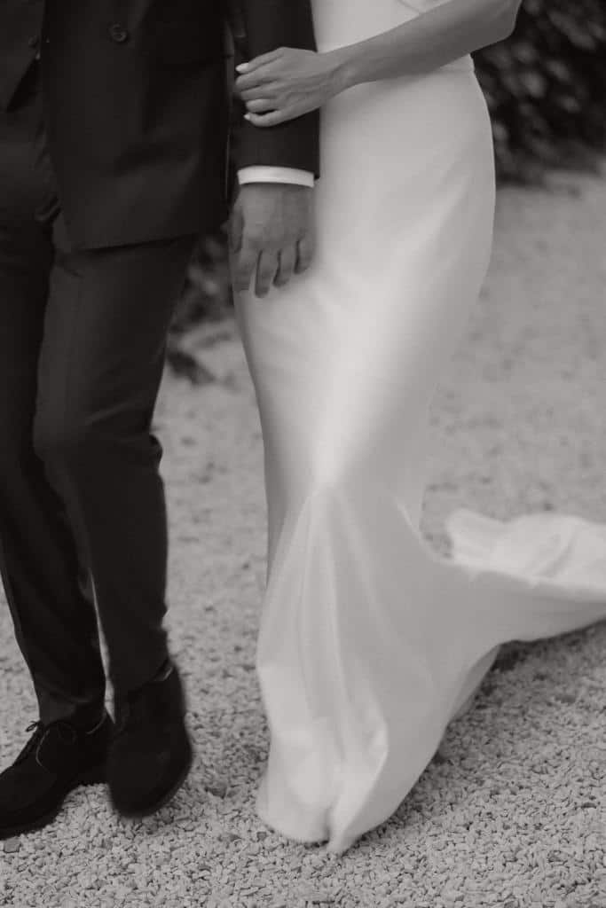 Hochzeitspaar Rückenansicht, Anzug und Brautkleid mit Schleppe. schwarz-weißes Porträt