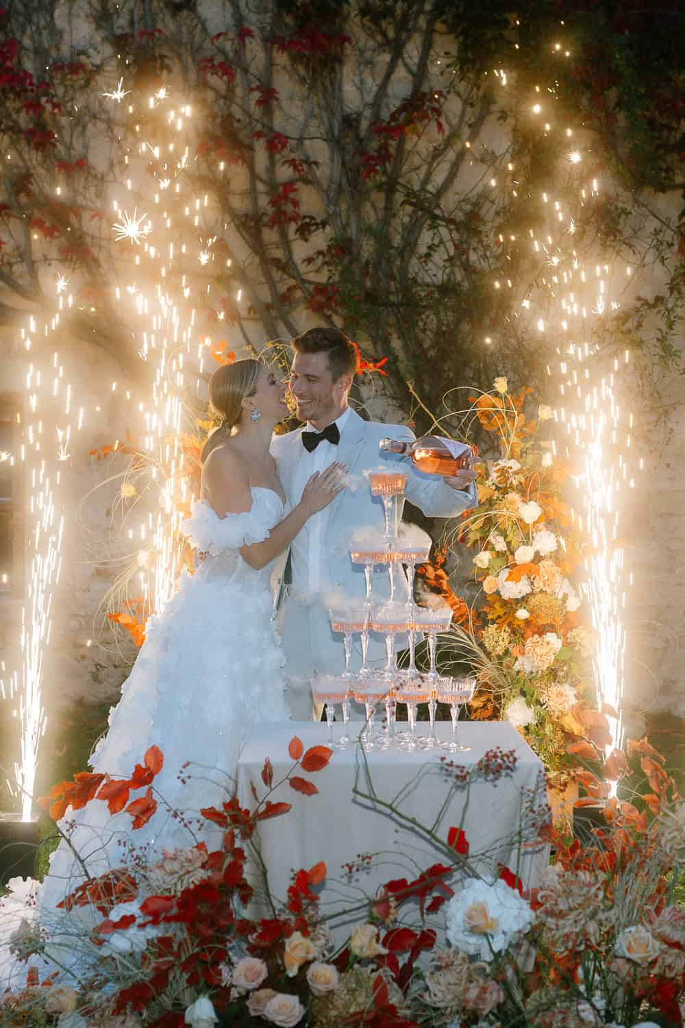 Brautpaar mit Champagnerturm, Blumen und Hochzeitsfeuerwerk im Schloss Haggenberg