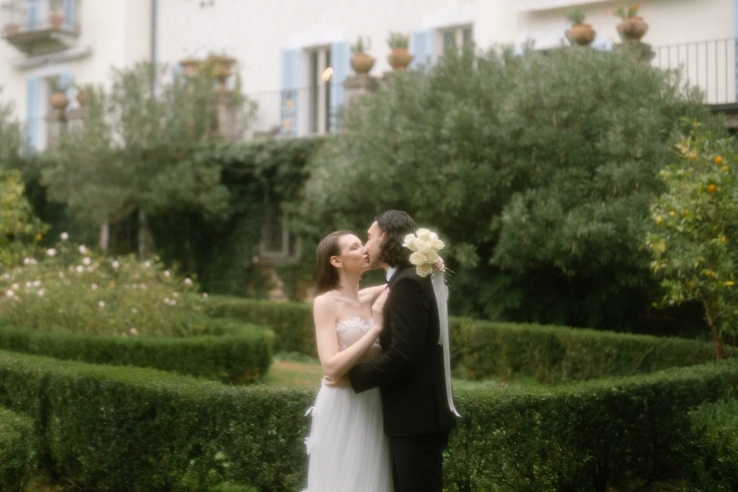 Braut und Bräutigam küssen im Garten, Hochzeit am Comer See