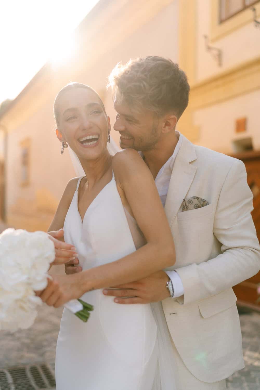Hochzeitspaar draußen, Braut mit Blumenstrauß, glücklicher Moment bei der Hochzeit im Himmelblau