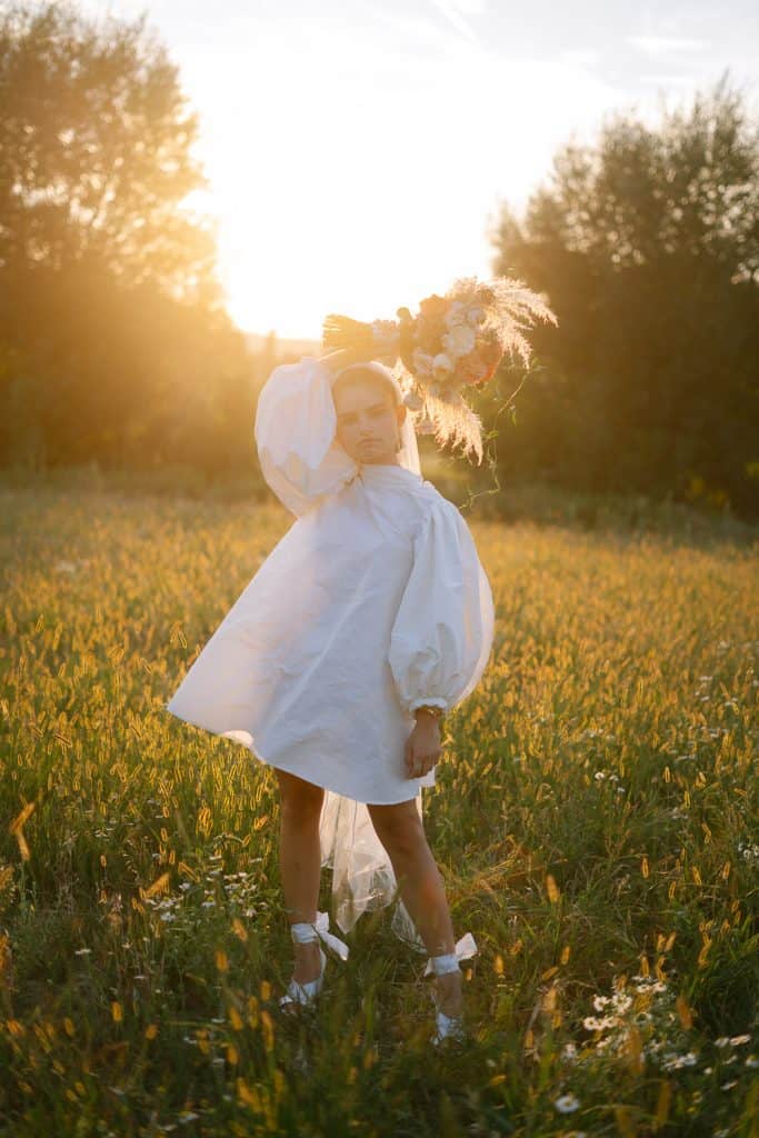 Braut mit Blumenstrauß im Sonnenlicht bei Stadtflucht Bergmühle.