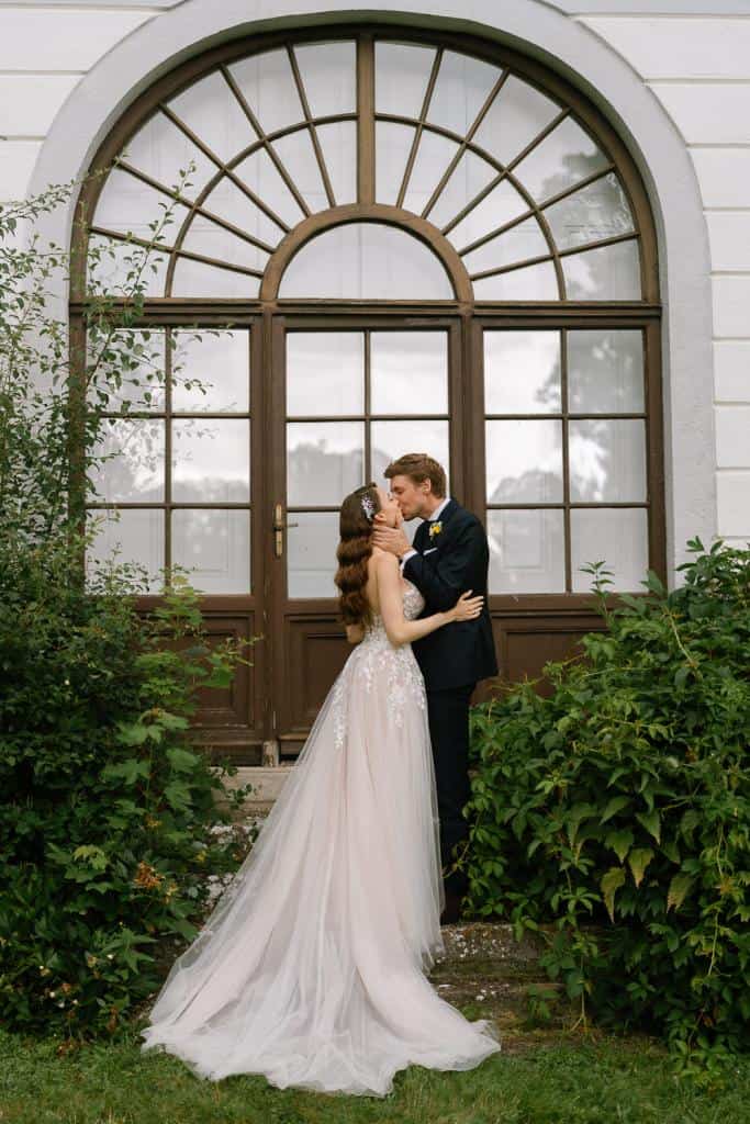 Brautpaar Kuss vor Fenster, Hochzeitsfoto im Schloss Nikitsch
