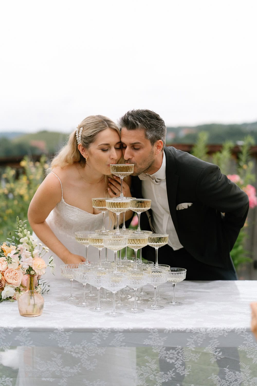 Braut und Bräutigam trinken Champagner Hochzeitsturm draußen.