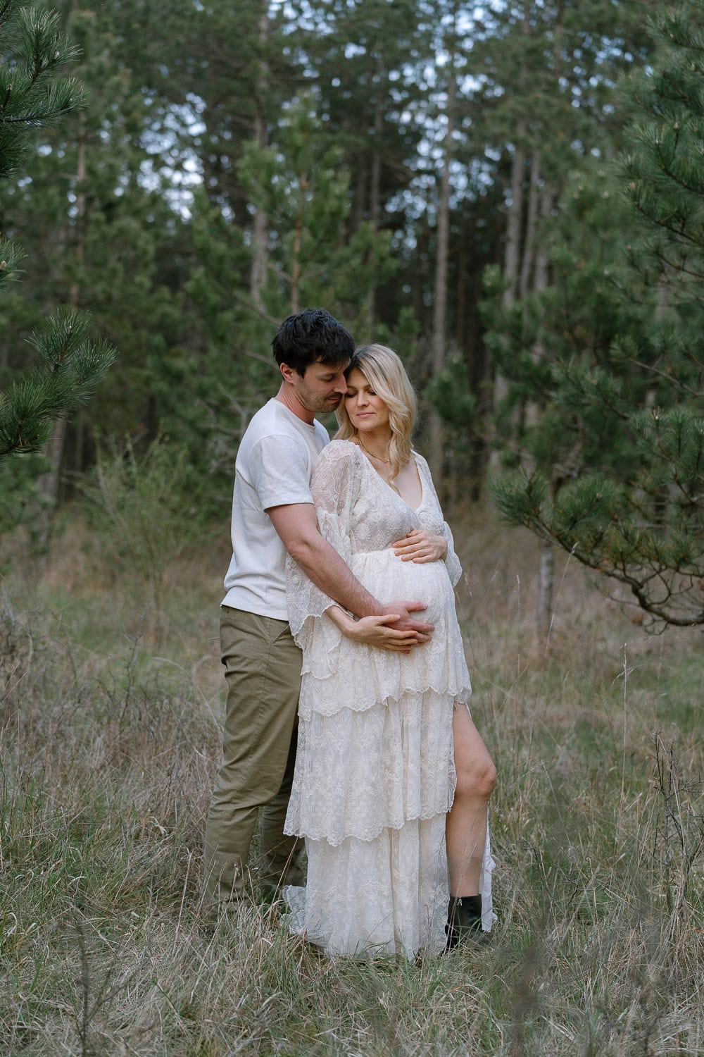 Schwangerschaft Fotoshooting Paar Wald, Umarmung weißes Spitzenkleid.