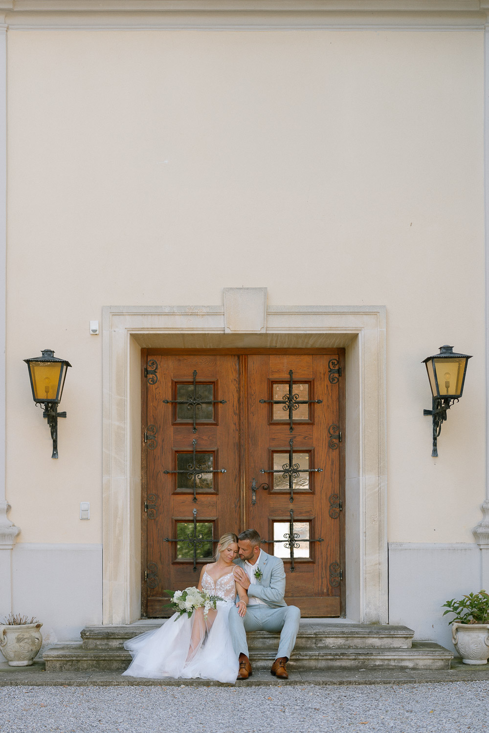 Brautpaar vor hölzerner Schloss Gurhof Tür, Hochzeit Blumenstrauß.