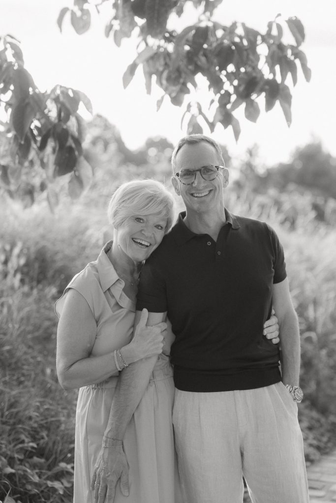 Älteres Paar umarmt im Freien, lächelnd, Schwarz-Weiß-Foto Natur.