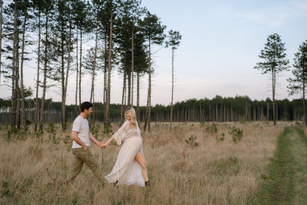 Paar Shooting Location Wiese Hand in Hand weiße Kleidung Bäume.