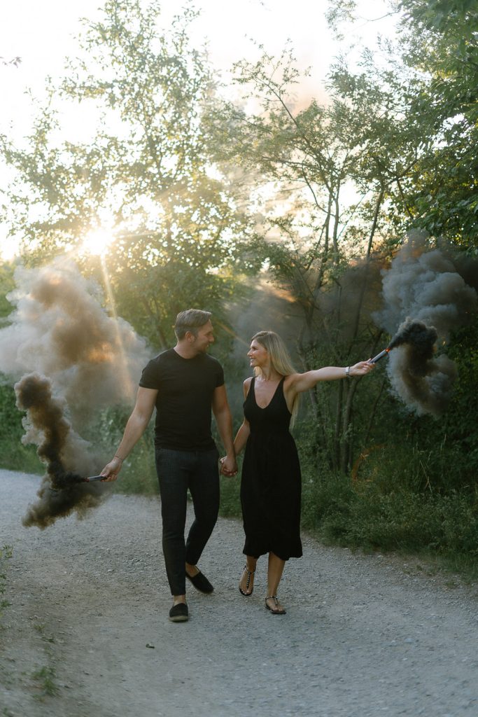 Paarshooting Standort: Paar mit Rauchbombe, Hand in Hand, Sonnenlicht.