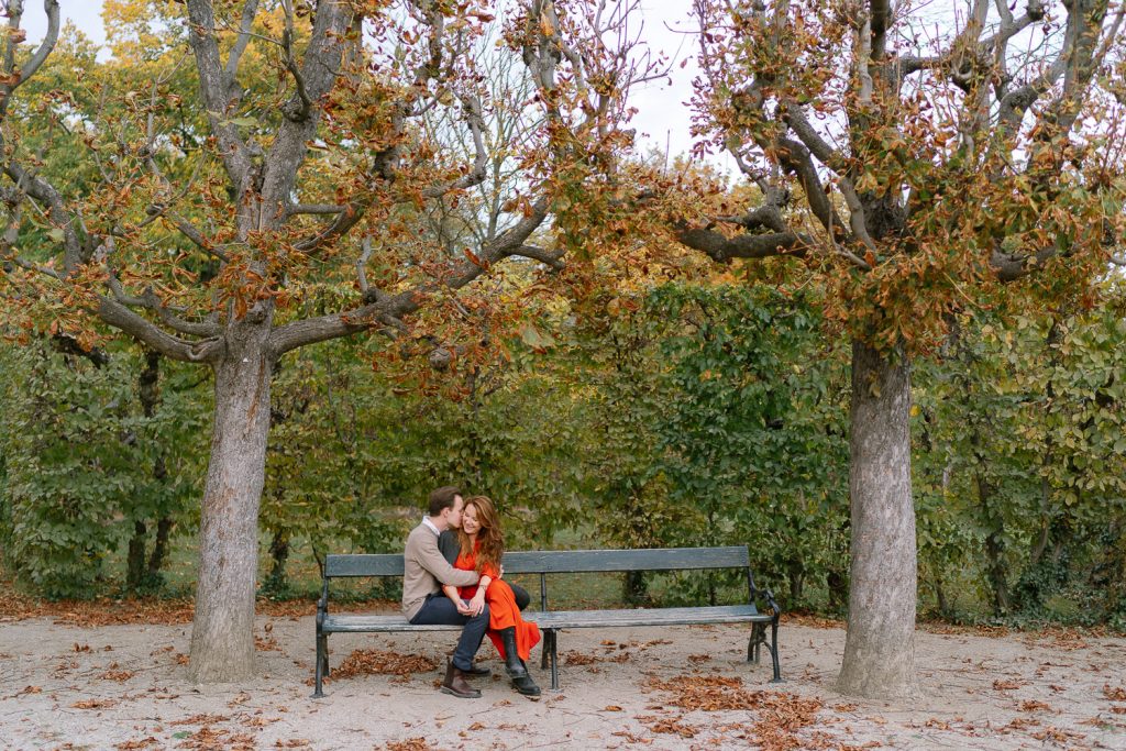 Paar auf Parkbank unter Herbstbäumen, romantisches Fotoshooting.