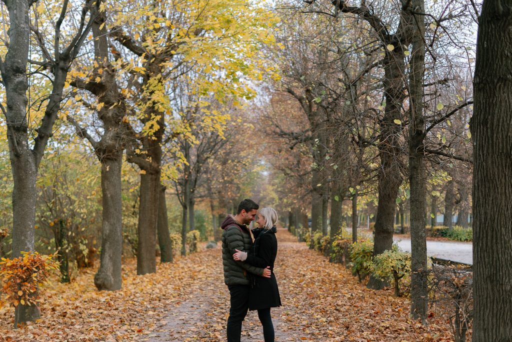 Paar auf herbstlichem Baumweg, romantische Fotoshooting-Location, Laub, Natur.