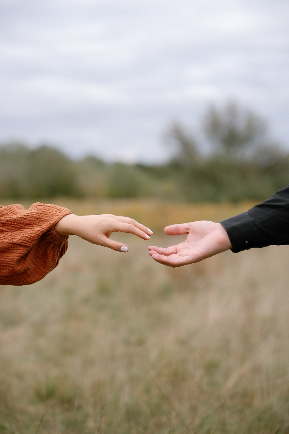 Zwei sich berührende Hände bei einem Babybauchshooting in Wien, Detailaufnahme