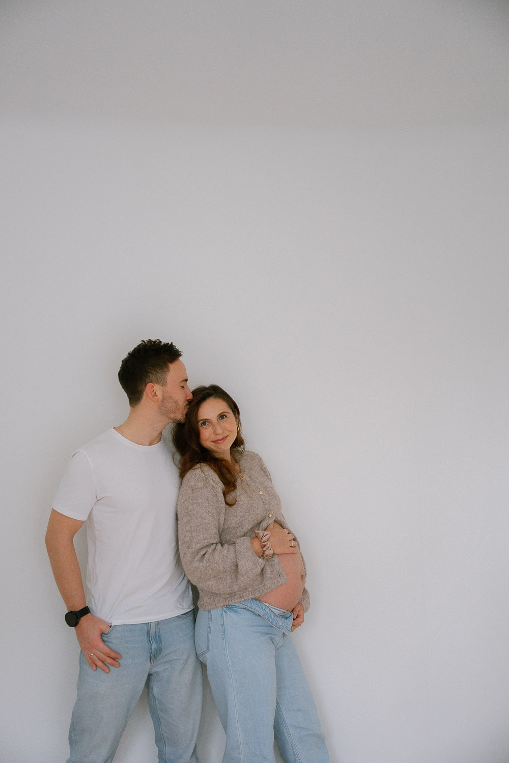 Zärtlicher Moment zwischen werdenden Eltern – Babybauchfotos in vertrauter Atmosphäre zu Hause