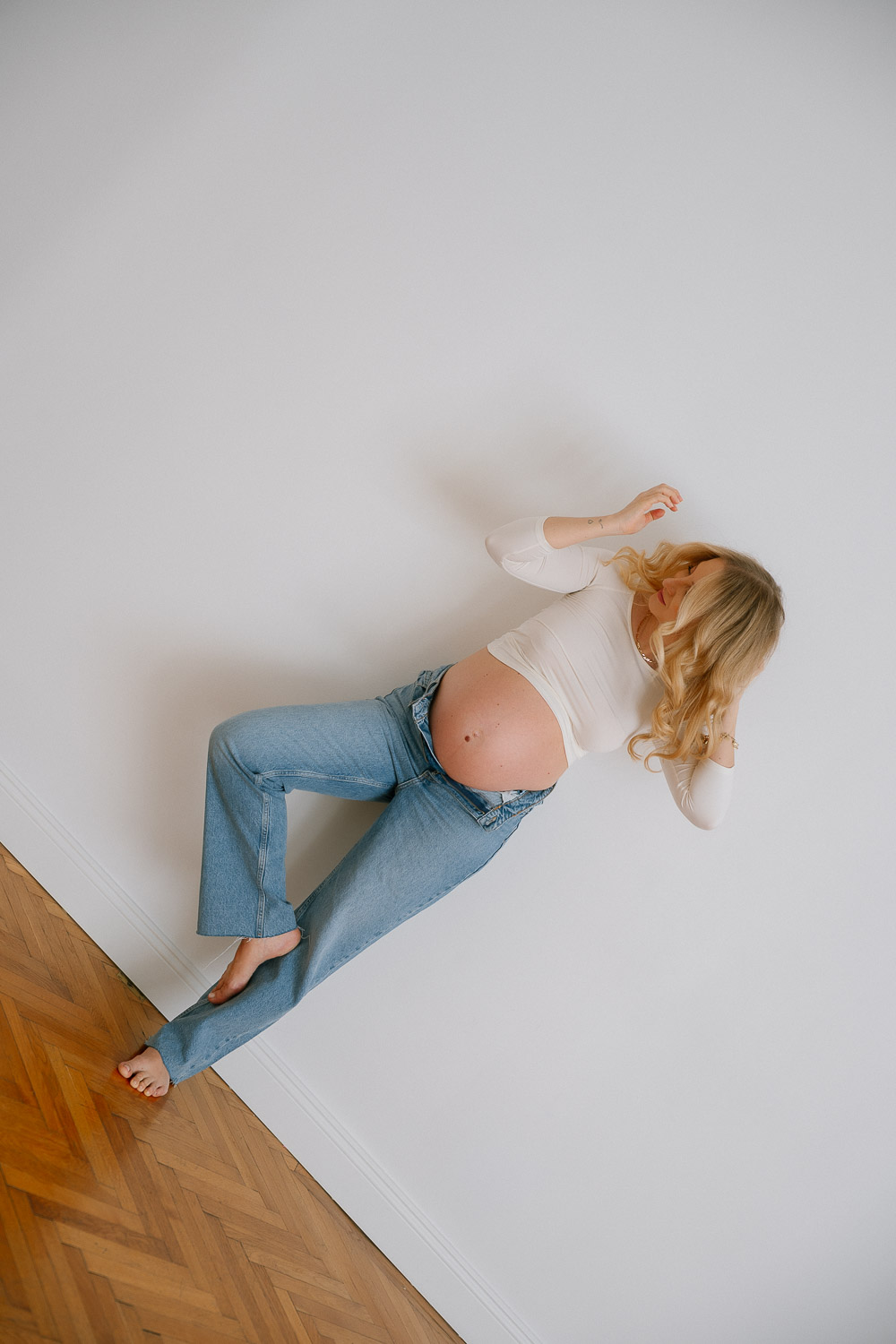 Schwangerschaftsfoto mit offener Jeans in Wien, moderne Pose mit Babybauch
