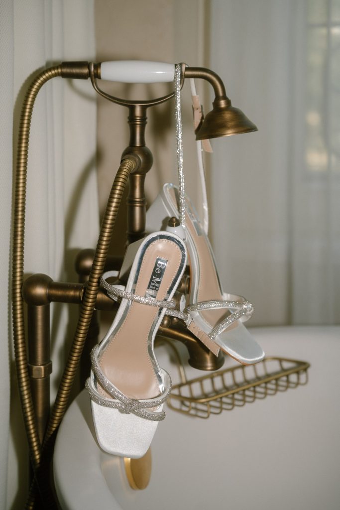 Brautschuhe mit Perlen und Absatz elegant inszeniert im Hotelzimmer