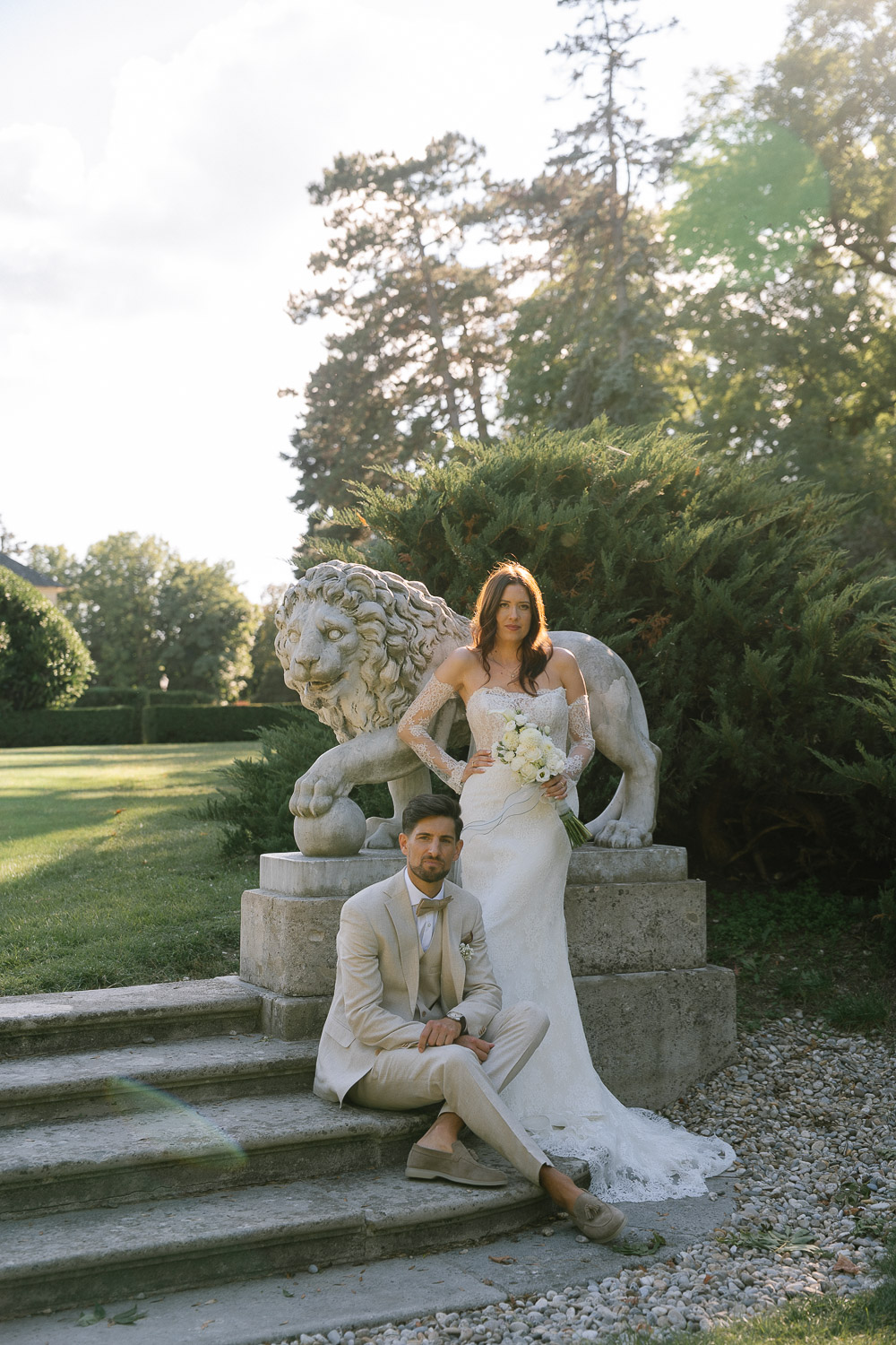 Brautpaar vor einer Löwenstatue im Garten von Schloss Laxenburg
