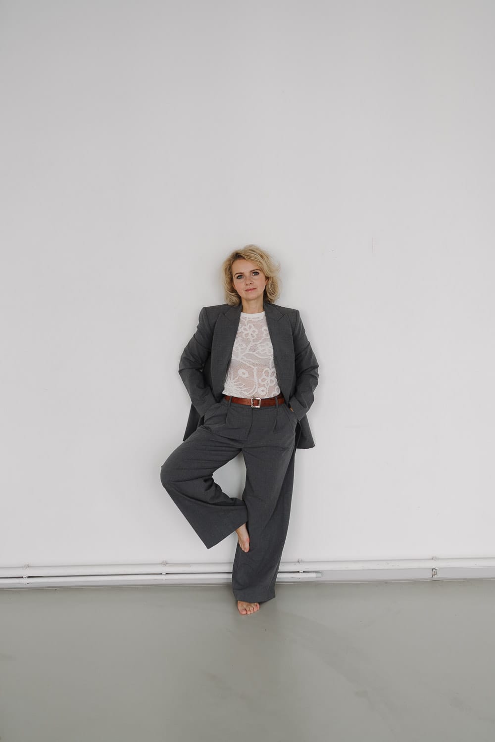 Modernes Porträt: Barfußblondine im grauen Anzug, Aschaaa Photography Stil.